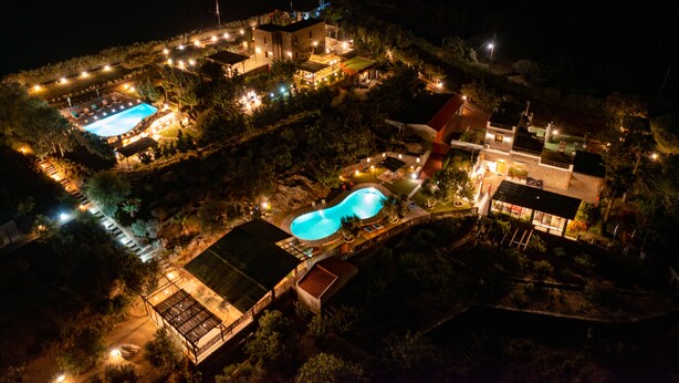 An aerial view of a resort with multiple swimming pools, well-lit pathways, and various buildings. - Green Island Resort Kea (Kea)