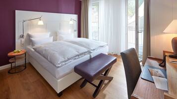 Une chambre d’hôtel moderne avec un grand lit, un bureau et une vue sur l’extérieur.