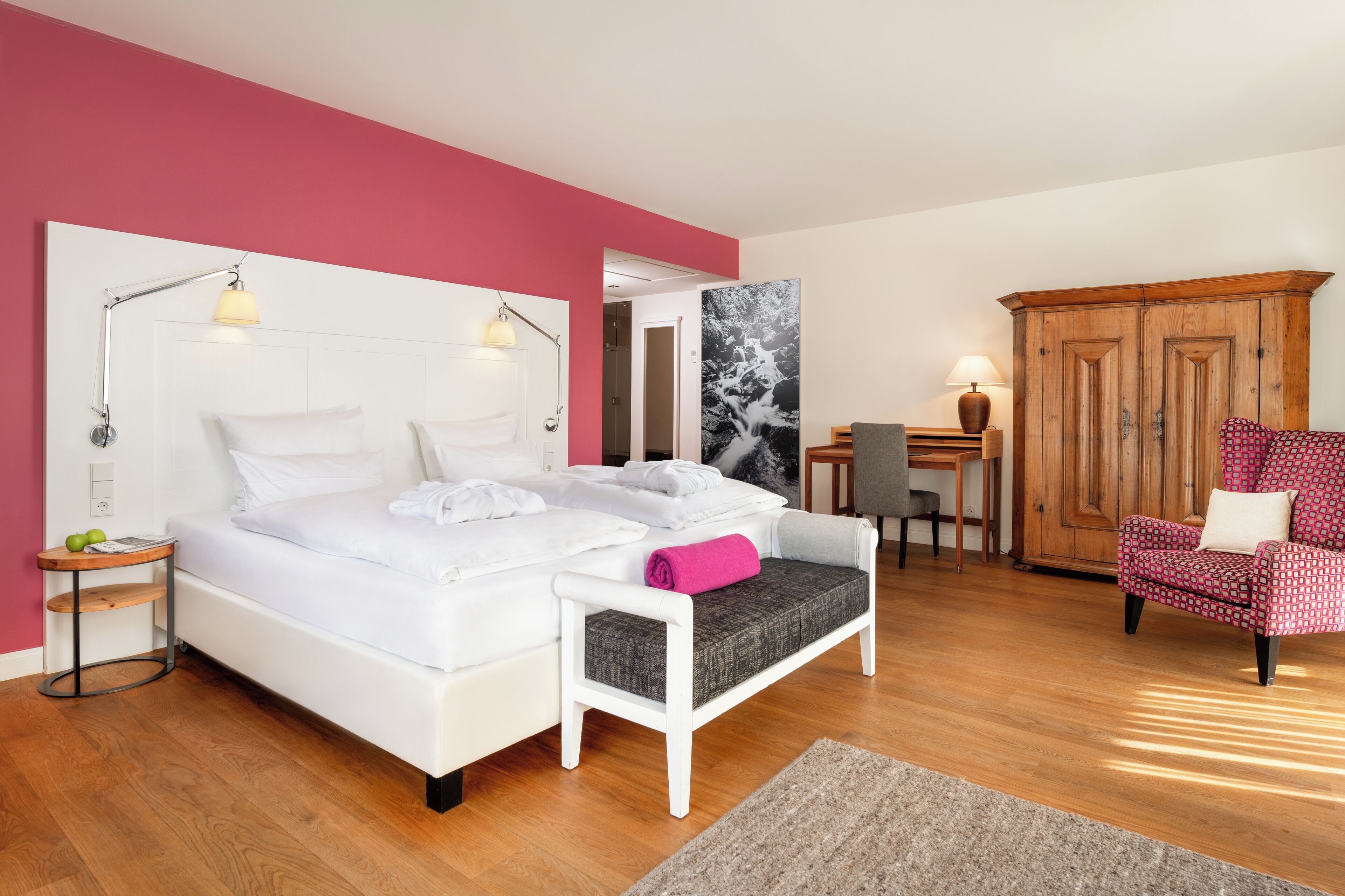 Un dormitorio moderno con una cama blanca, un escritorio, una silla y un armario.