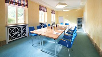 A conference room with a long table, blue chairs, and a whiteboard.