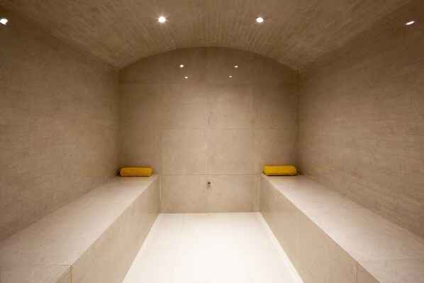 Un baño moderno y minimalista con techo curvo e iluminación empotrada.