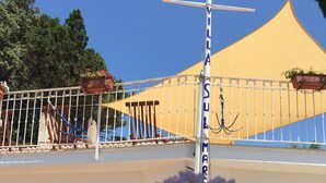 Un bâtiment doté d’un auvent jaune, d’une clôture blanche et d’une enseigne sur laquelle on peut lire « VILLA SUL MAR ».