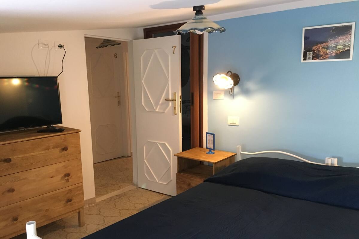 Une chambre à coucher comprenant un lit, une commode, un bureau et une table de chevet.