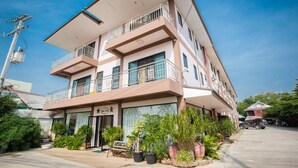 A multi-story hotel with balconies, a coffee shop, and potted plants in the courtyard. - The Star Hotel (Udon Thani)