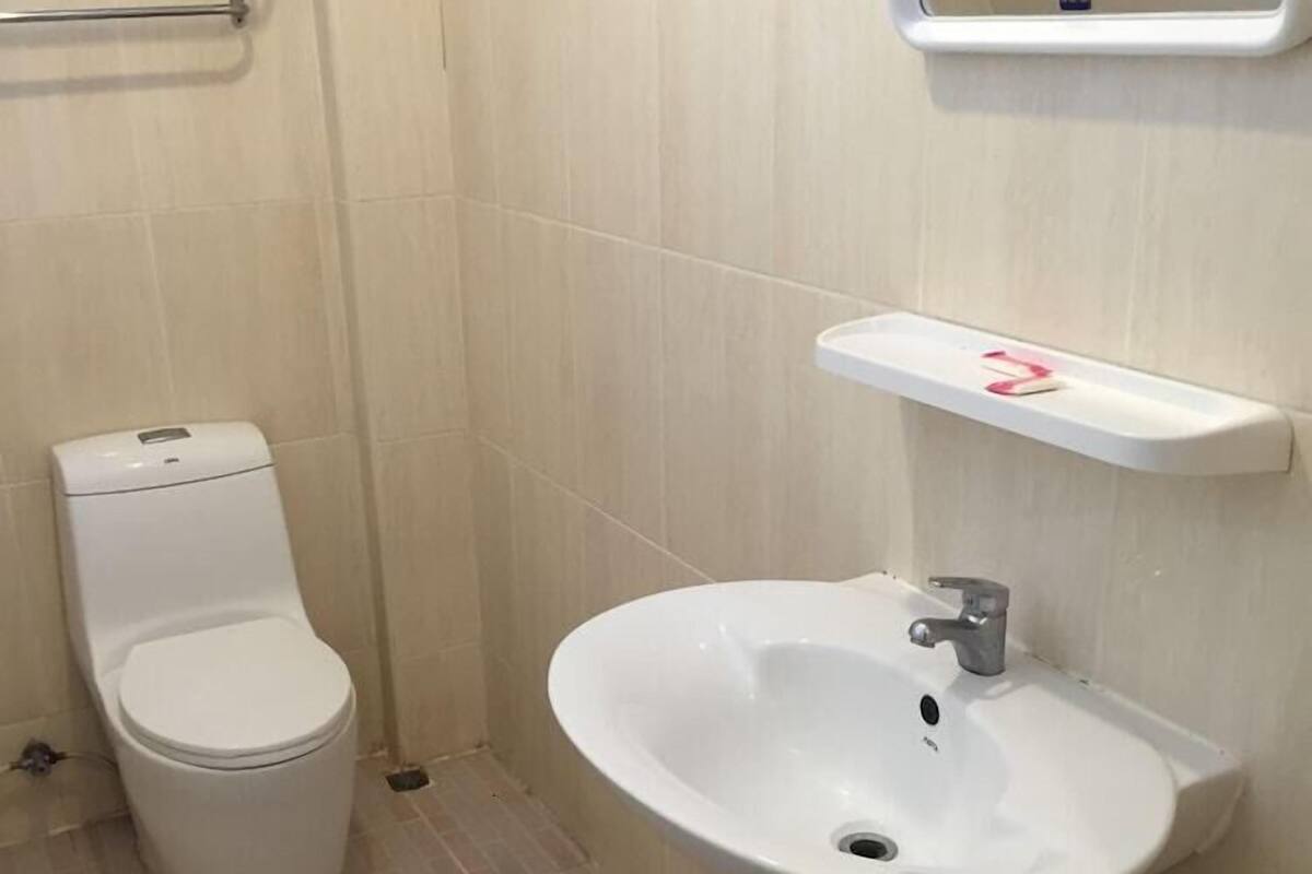 A bathroom with a toilet, a sink, and a mirror.
