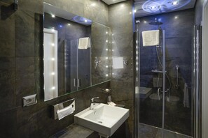 Habitació triple Deluxe, vistes a la ciutat | Bany | Dutxa, articles de tocador gratuïts, assecador de cabells i barnussos 