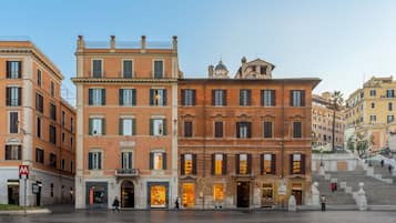 Een historisch gebouw met meerdere verdiepingen, grote ramen en een opvallende trap die naar een hoger niveau leidt.
