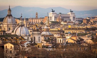 Paesaggio urbano con architettura storica, tra cui edifici a cupola e statue.