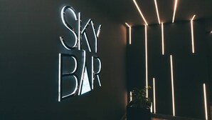 A wall with illuminated signage reading "SKY BAR" and vertical light strips. - Star Land Hotel Bonapriso (Douala)