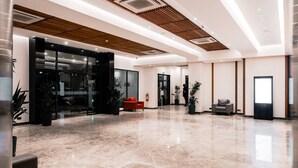 A spacious lobby with a polished marble floor, a reception desk, and seating areas. - Star Land Hotel Bonapriso (Douala)