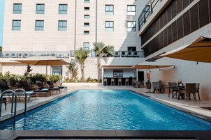 Una piscina al aire libre, sillones reclinables de piscina