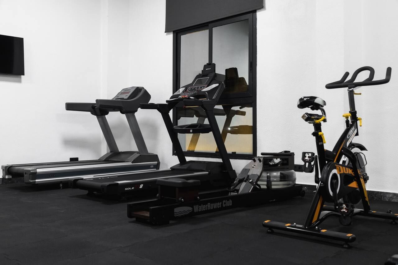 A gym with a treadmill, elliptical, and stationary bike.