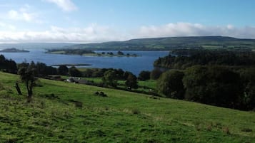 A scenic view of a lake surrounded by hills and greenery.