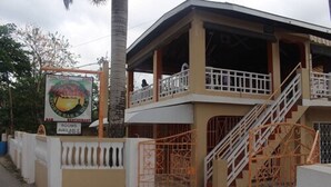 A two-story building with a balcony and a staircase. - Paradise on the Rocks (Negril)
