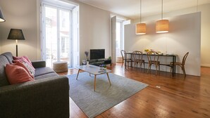 Een moderne woonkamer met een bank, salontafel en een eethoek.