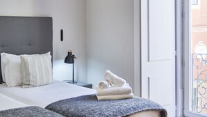 Een moderne slaapkamer met een groot bed, nachtkastjes en uitzicht.