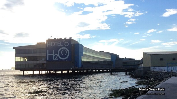 A hotel with a large sign reading "HOTEL o H2O" on a waterfront property. - ZEN Rooms Malate Nakpil (Manila)