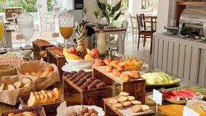 A buffet table with various food items, including bread, pastries, and fruits. - Hotel Premium Recanto da Passagem (Cabo Frio)