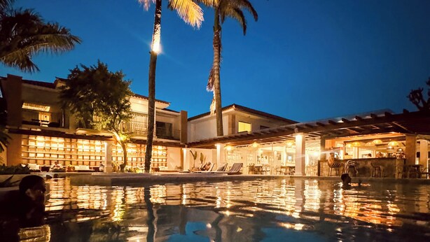 A resort pool area with palm trees, a bar, and lounge chairs. - Hotel Premium Recanto da Passagem (Cabo Frio)