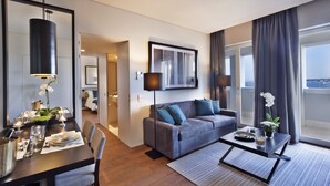 Een moderne hotelkamer met een zithoek, een bank en een groot raam met uitzicht.