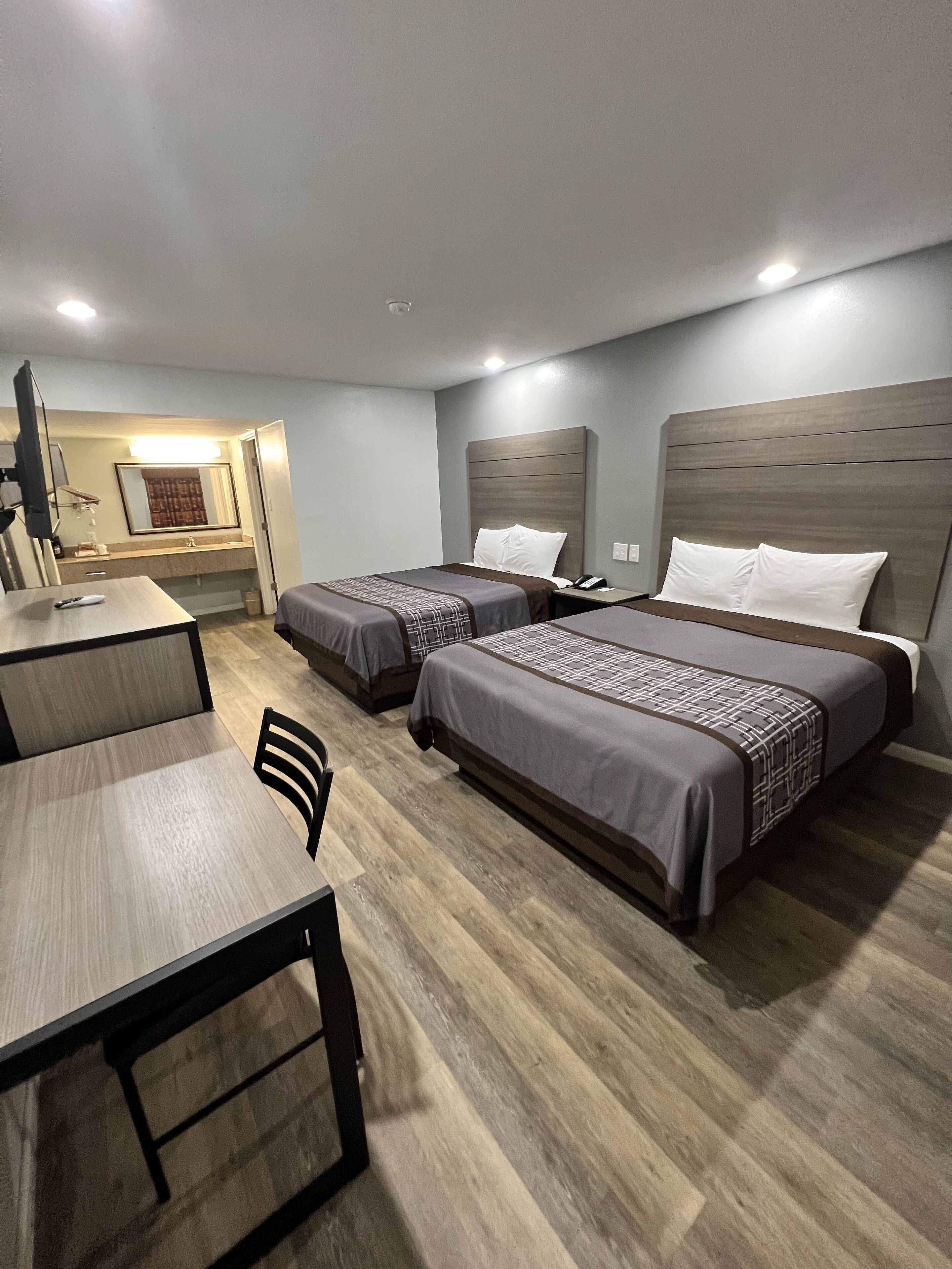 Una habitación de hotel con dos camas, un escritorio y una silla.