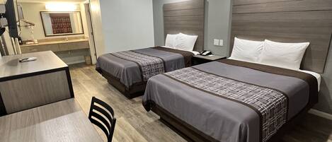 Una habitación de hotel con dos camas, un escritorio y una silla.