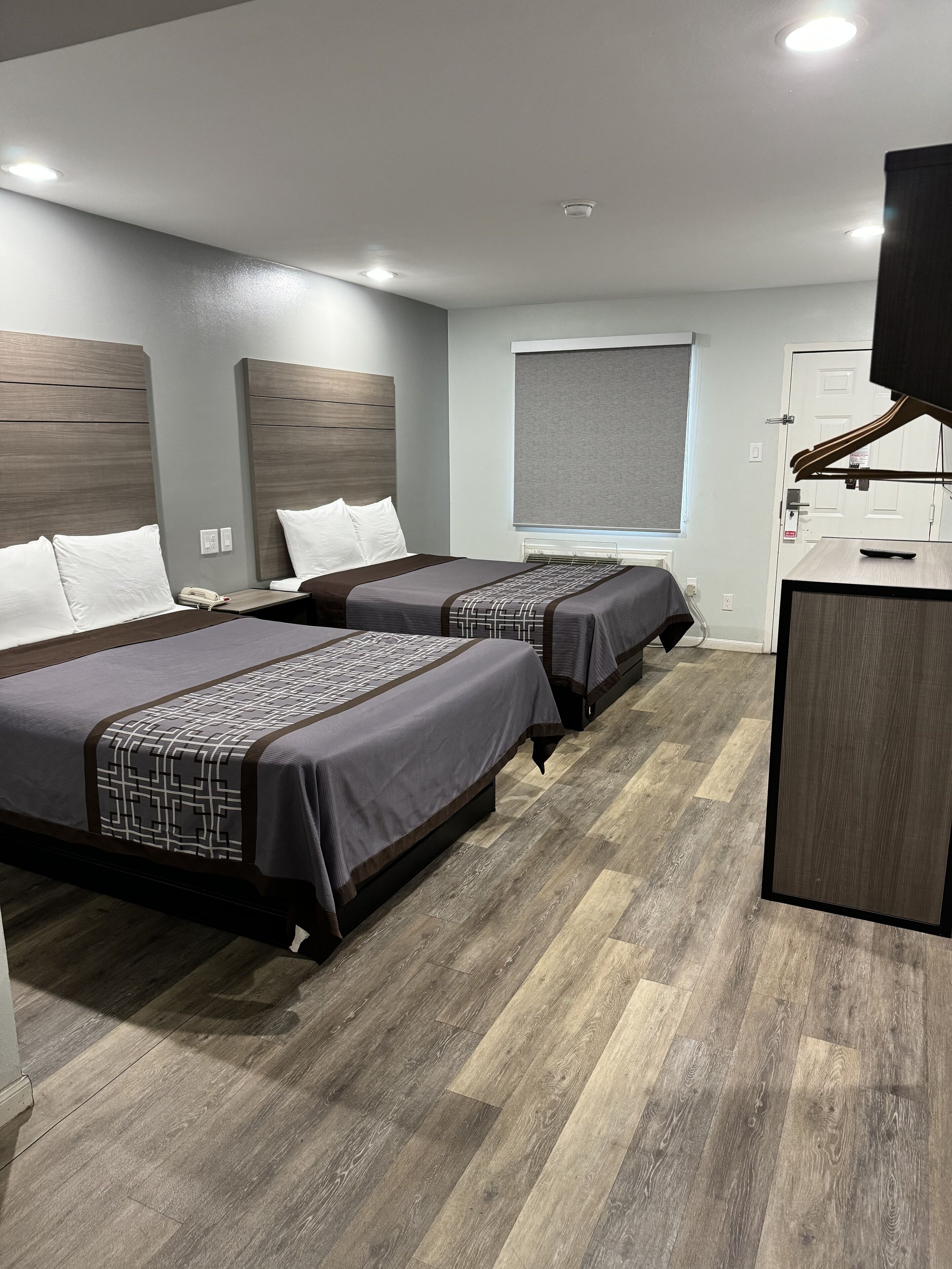 Une chambre d’hôtel avec deux lits, un bureau et une télévision.