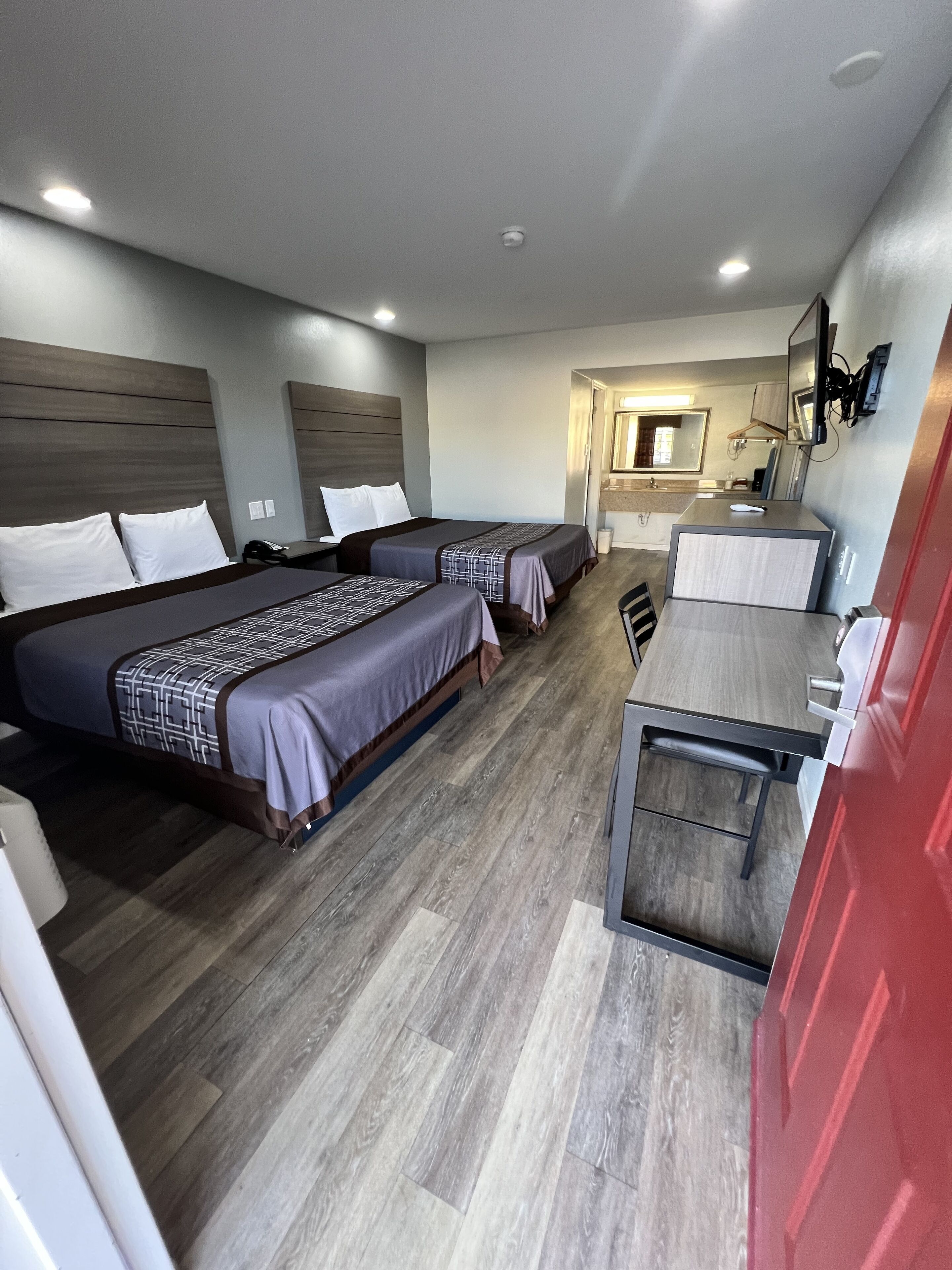 Une chambre d’hôtel avec deux lits, un bureau et une salle de bain.
