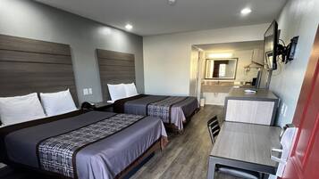 Une chambre d’hôtel avec deux lits, un bureau et une salle de bain.