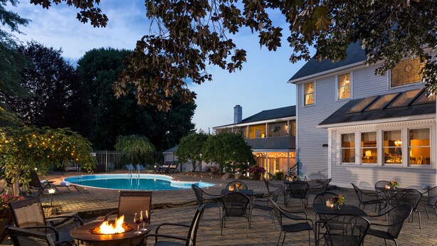A patio with outdoor seating and a pool. - The Jacqueline House of Wilmington (New Wilmington)
