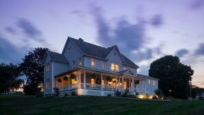 A large, two-story house with a porch and multiple windows, surrounded by a well-maintained lawn. - The Jacqueline House of Wilmington (New Wilmington)