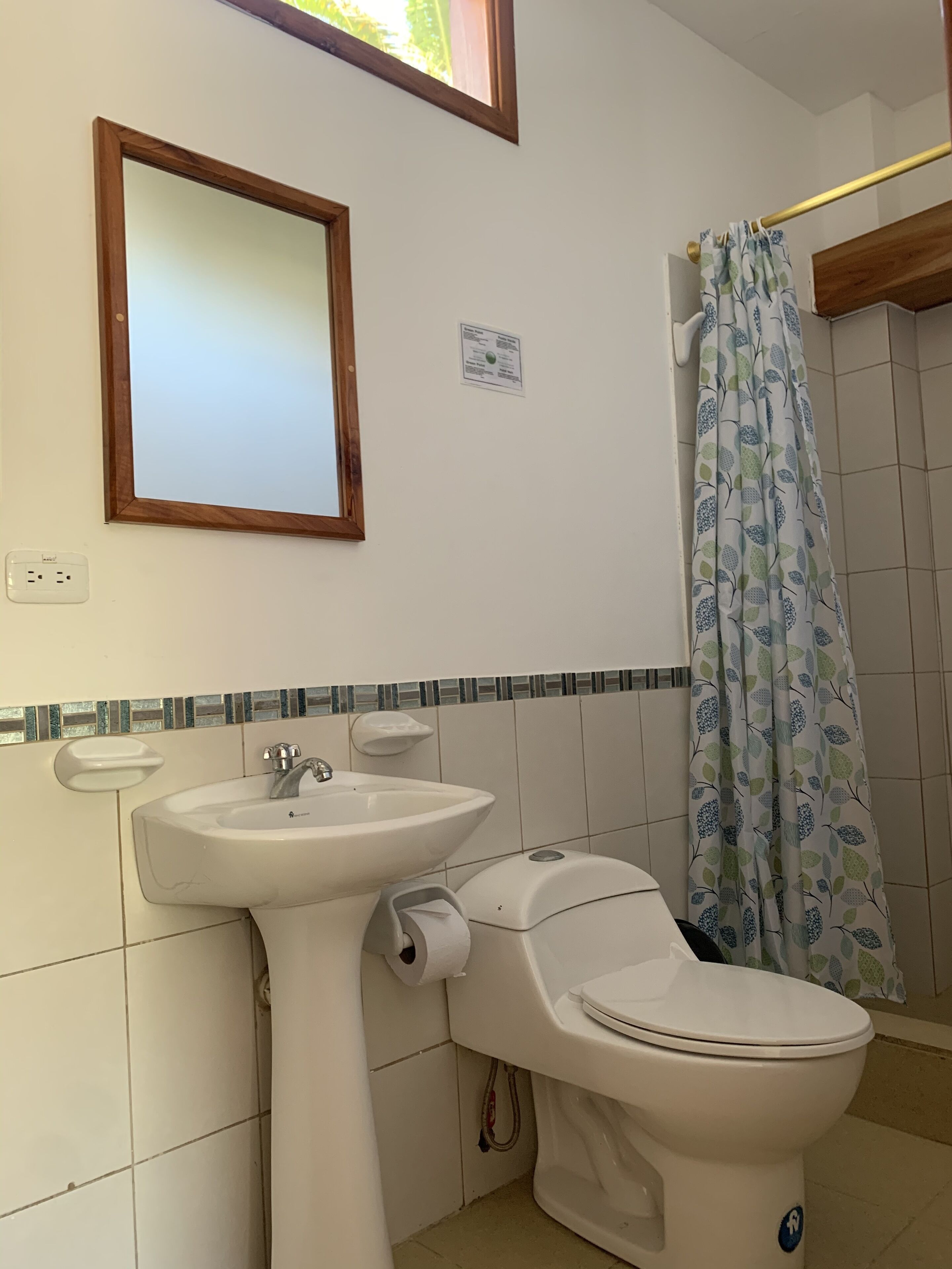 Une salle de bain équipée d’un lavabo, de toilettes et d’un rideau de douche.