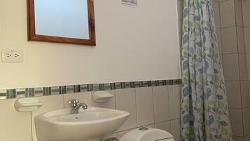 Une salle de bain équipée d’un lavabo, de toilettes et d’un rideau de douche.
