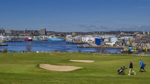 A golf course with bunkers and a water body in the background. - Aberdeen Lighthouse Cottages (Aberdeen)