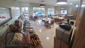Ein Bereich mit einem Buffet, verschiedenen Speisen und einem Fernseher im Hintergrund.