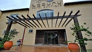 Ein Hotel Eingang mit einer Pergola, großen Kübelpflanzen und einem Schild mit der Aufschrift "Taounu Hotel Boutique".