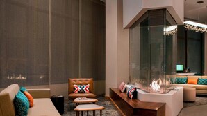 A modern living room with a sofa, armchair, and a glass fireplace. - Residence Inn by Marriott Boston Watertown (Watertown)