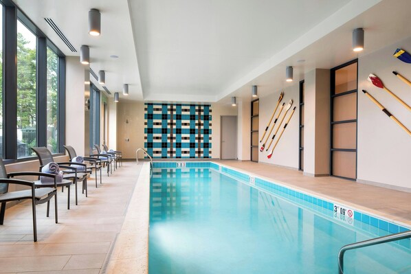A swimming pool with lounge chairs and a wall with a geometric pattern. - Residence Inn by Marriott Boston Watertown (Watertown)