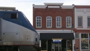 A train station with a brick building labeled "ANTIQUE" and a storefront. - The Tinder Guest House (Ashland)