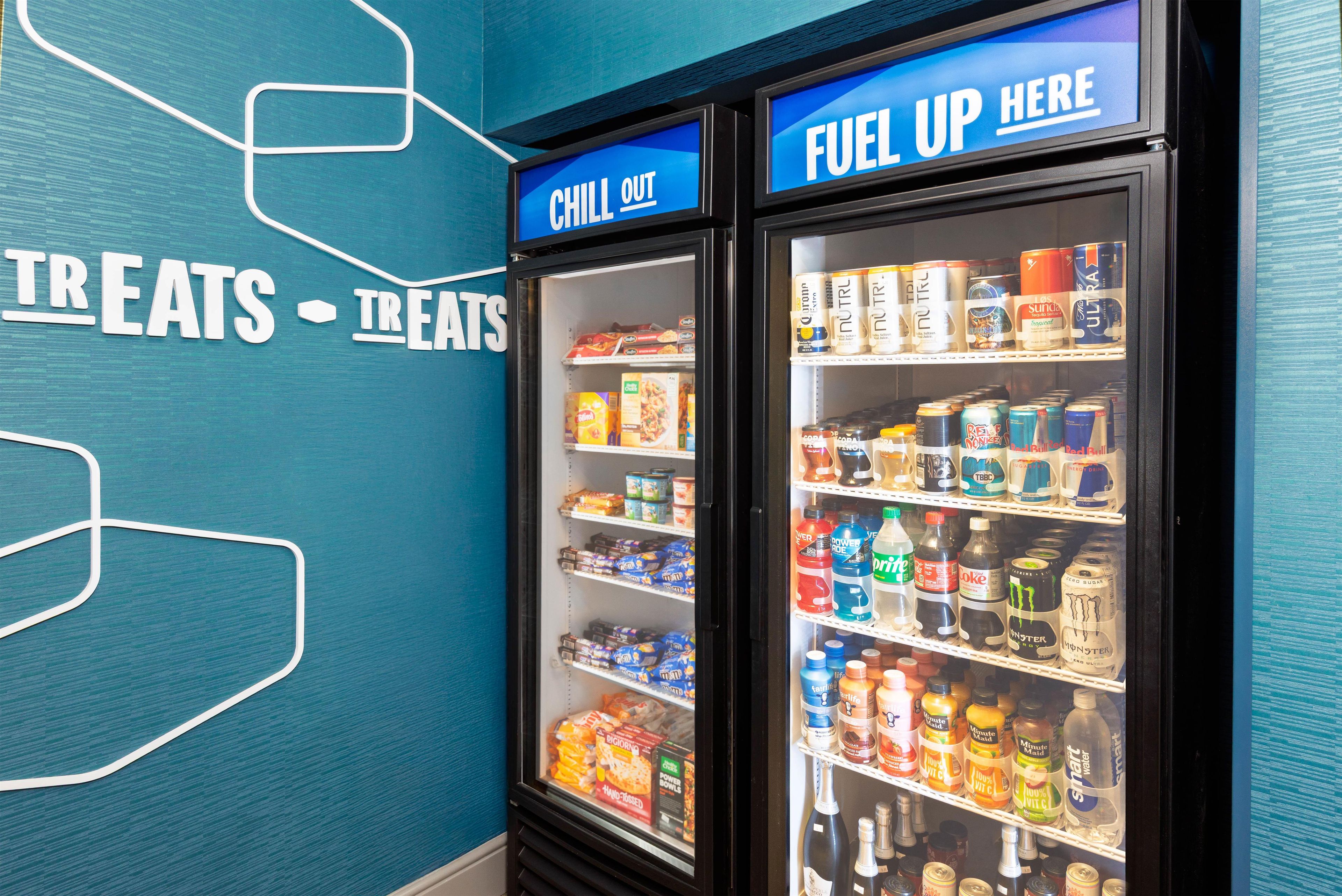 Two beverage dispensers labeled 'CHILL OUT' and 'FUEL UP HERE' with various drinks and snacks inside.