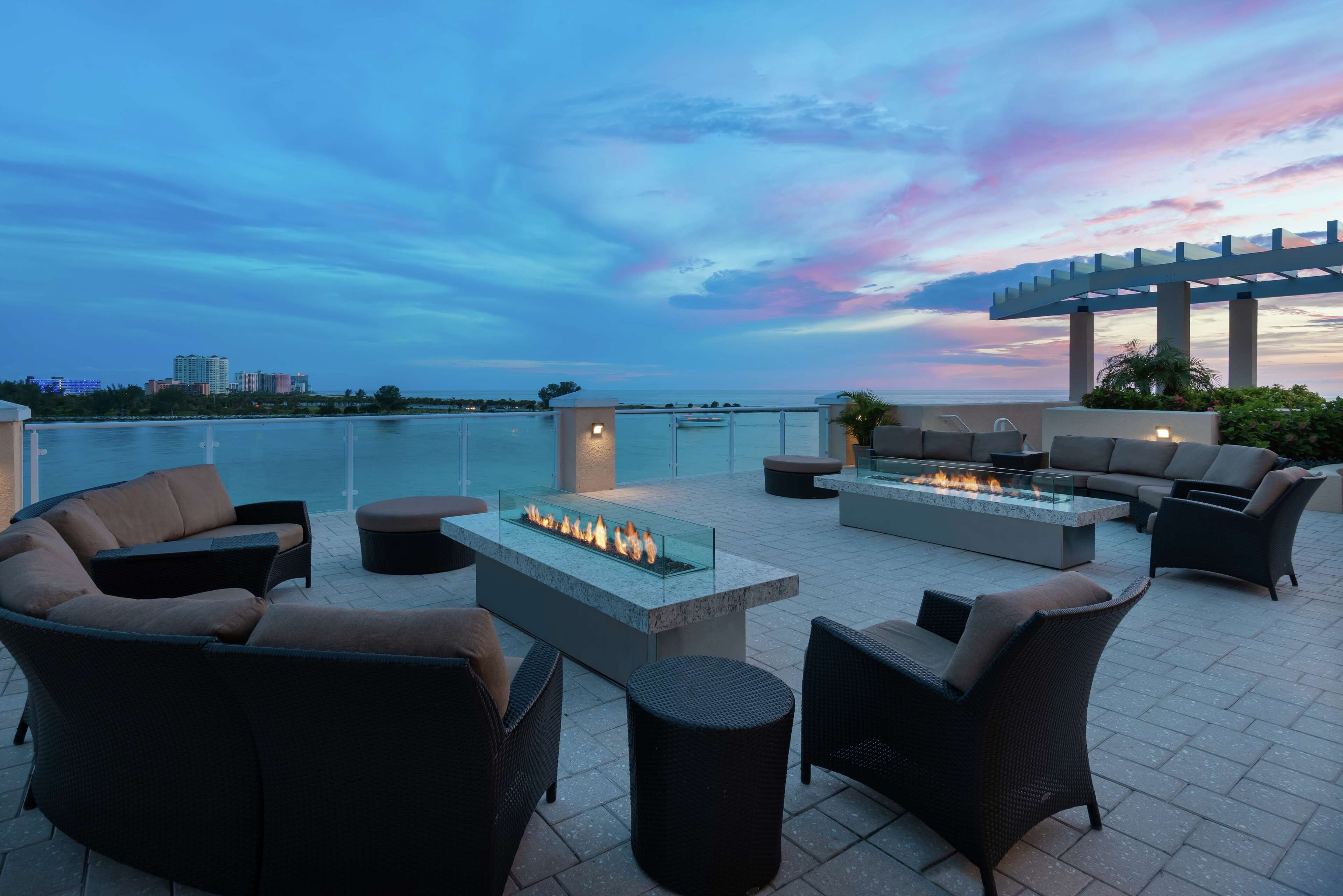 An outdoor seating area with a fire feature and a view of the ocean.