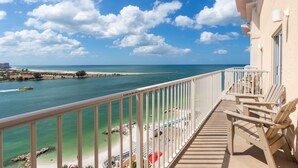 A balcony with a view of a beach and ocean.