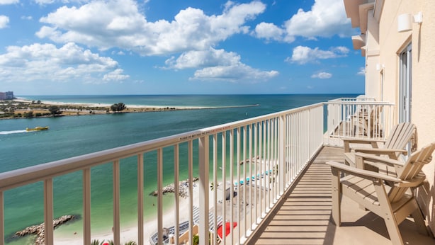 A balcony with a view of a beach and ocean.