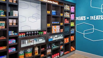 A store with shelves stocked with snacks and beverages, a sign reading 'welcome to Clearwater beach', and a wall with a geometric design.