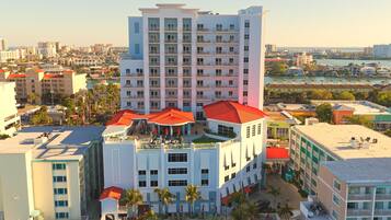 A multi-story hotel with a pool area, outdoor seating, and a view of the surrounding cityscape.