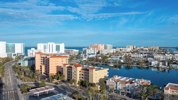 A coastal cityscape with a marina, high-rise buildings, and a clear sky.