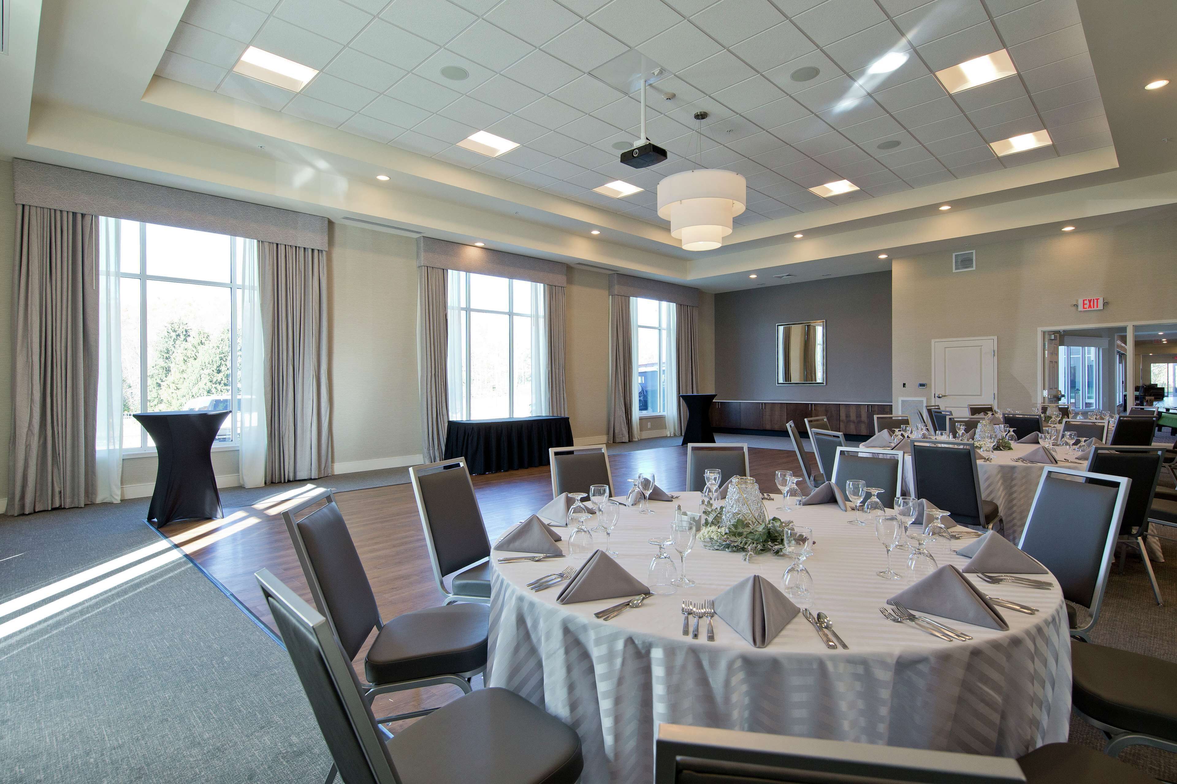A conference room with round tables, chairs, and a projector.