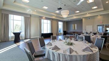 A conference room with round tables, chairs, and a projector.