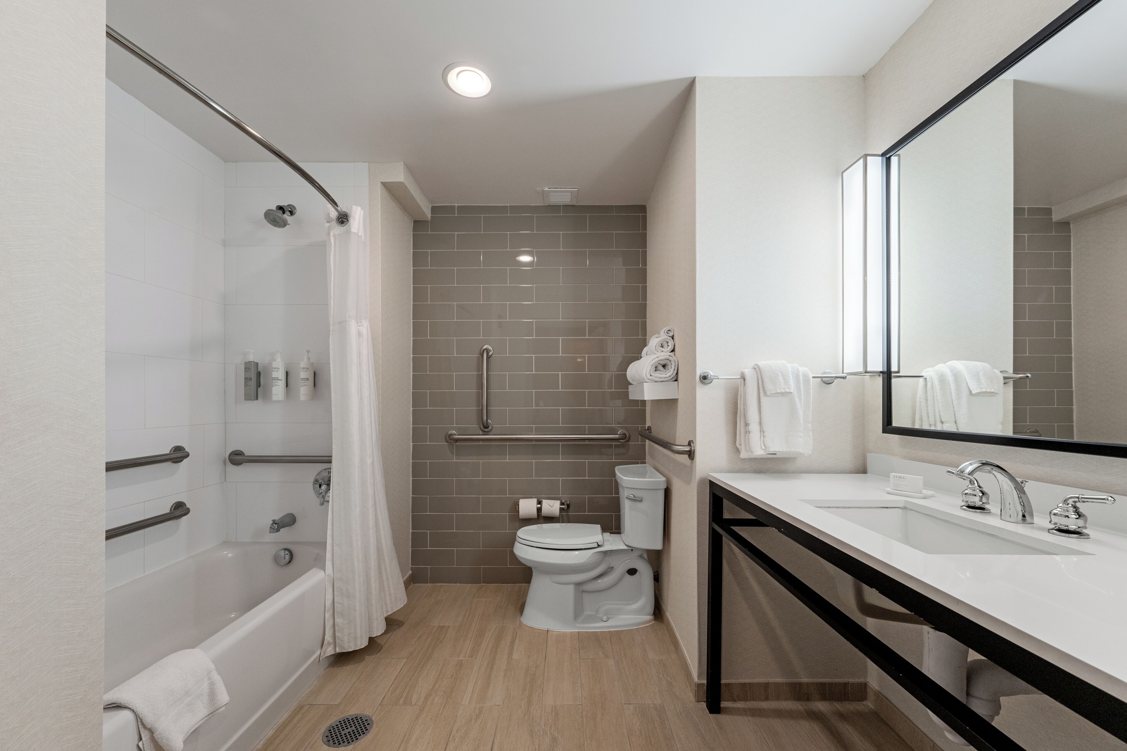 A modern bathroom with a shower, toilet, and sink.