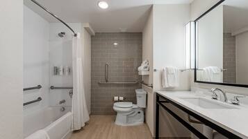 A modern bathroom with a shower, toilet, and sink.